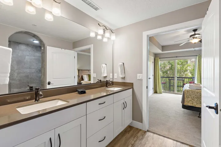 Dual vanity with white cabinetry, brown countertops, and matte black fixtures