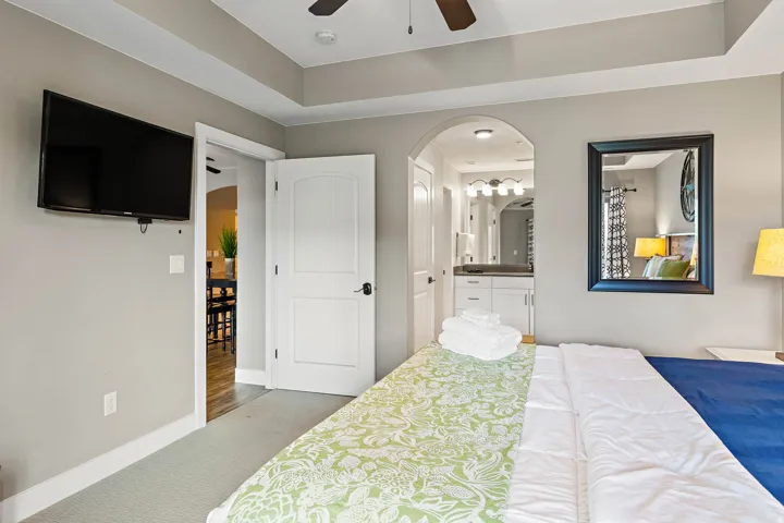 Carpeted bedroom with a tray ceiling and ceiling fan