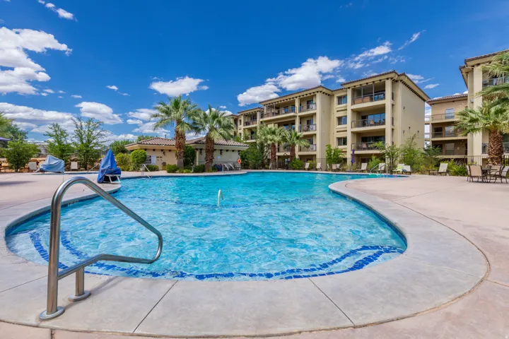 Resort-style swimming pool featuring a curved design, integrated spa, and fountain