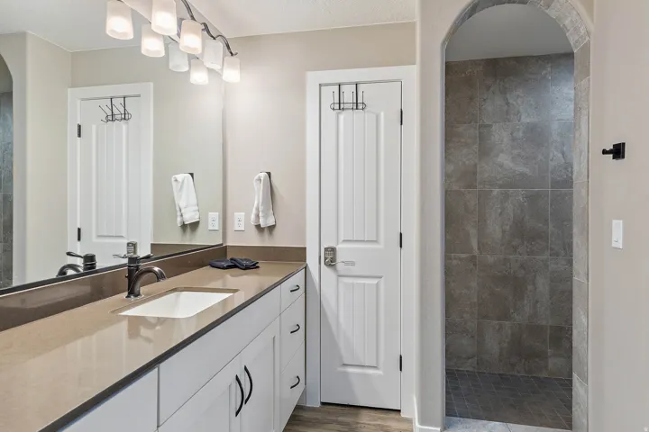 Bathroom featuring a wide vanity with a rectangular undermount sink, a dark bronze faucet, and white cabinetry