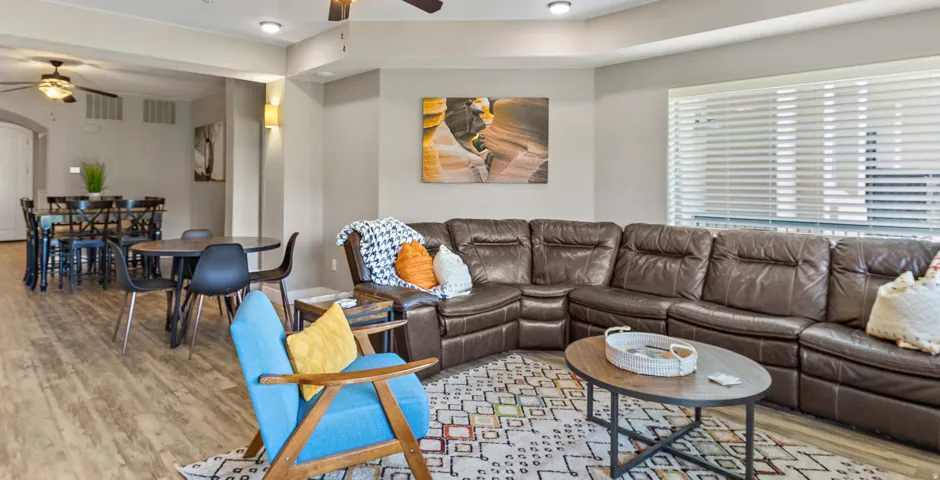 Open-concept living space featuring wood-finish flooring, recessed lighting, and a window with horizontal blinds