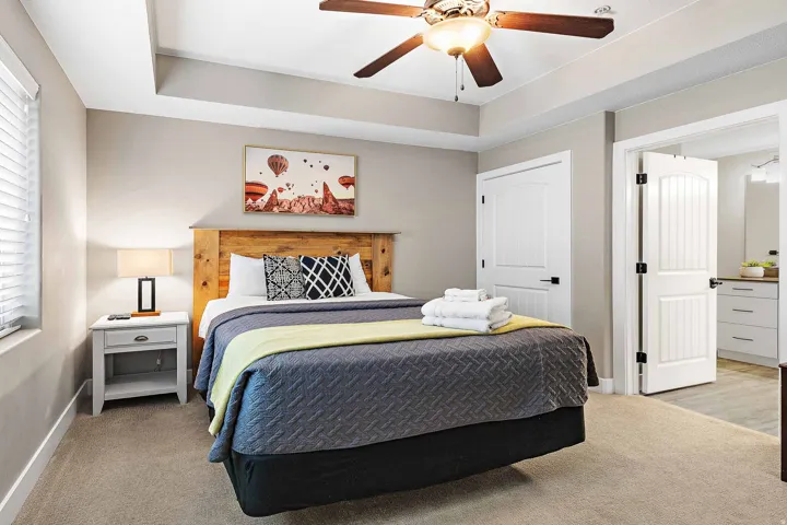 Bedroom featuring a tray ceiling with a ceiling fan