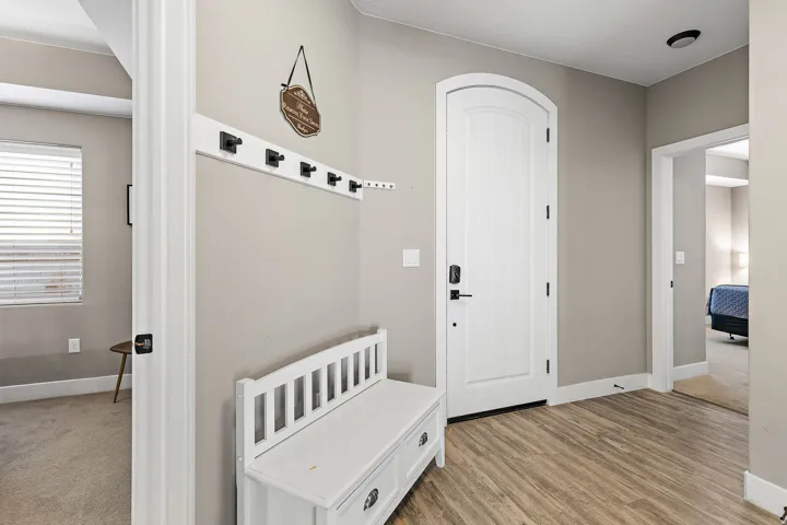 Entryway featuring wood-finish flooring, light gray wall tones, and a white arched panel door