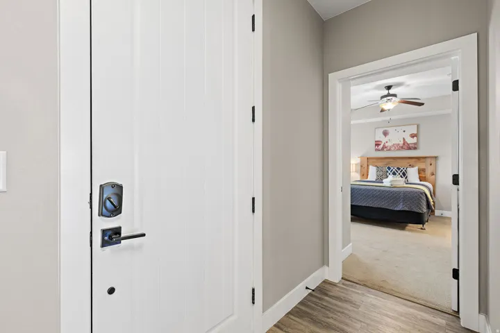 Hallway featuring wood-finish flooring, light gray wall paint, and white trim