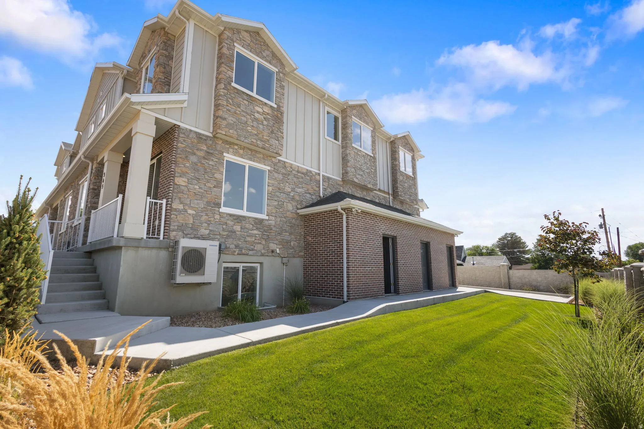 Stone and brick veneer exterior featuring multiple dormers and white trim