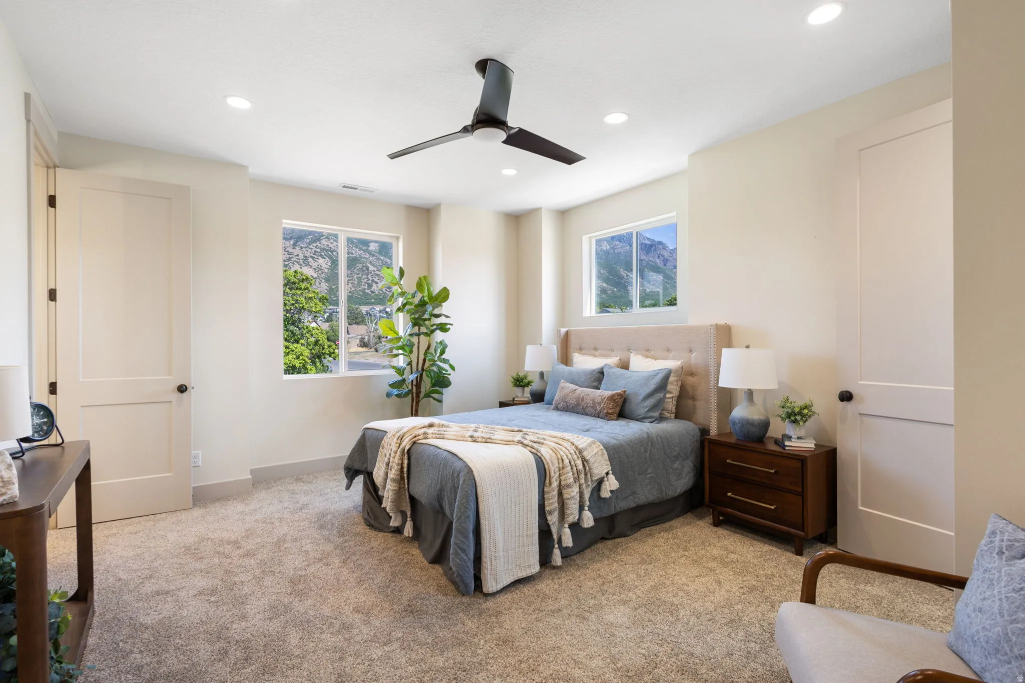Carpeted room featuring multiple windows with mountain scenery