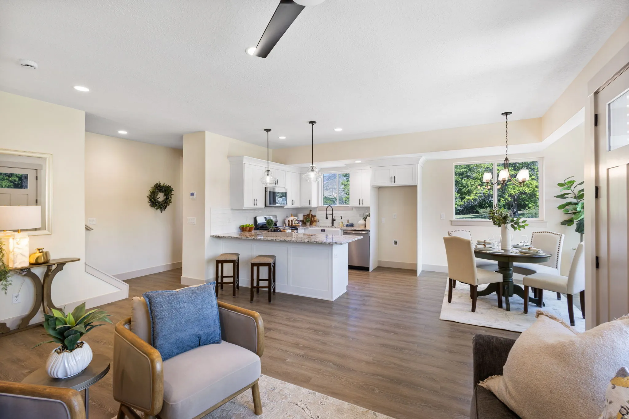Open-concept living area featuring wood-finish flooring, recessed lighting, and a modern ceiling fan