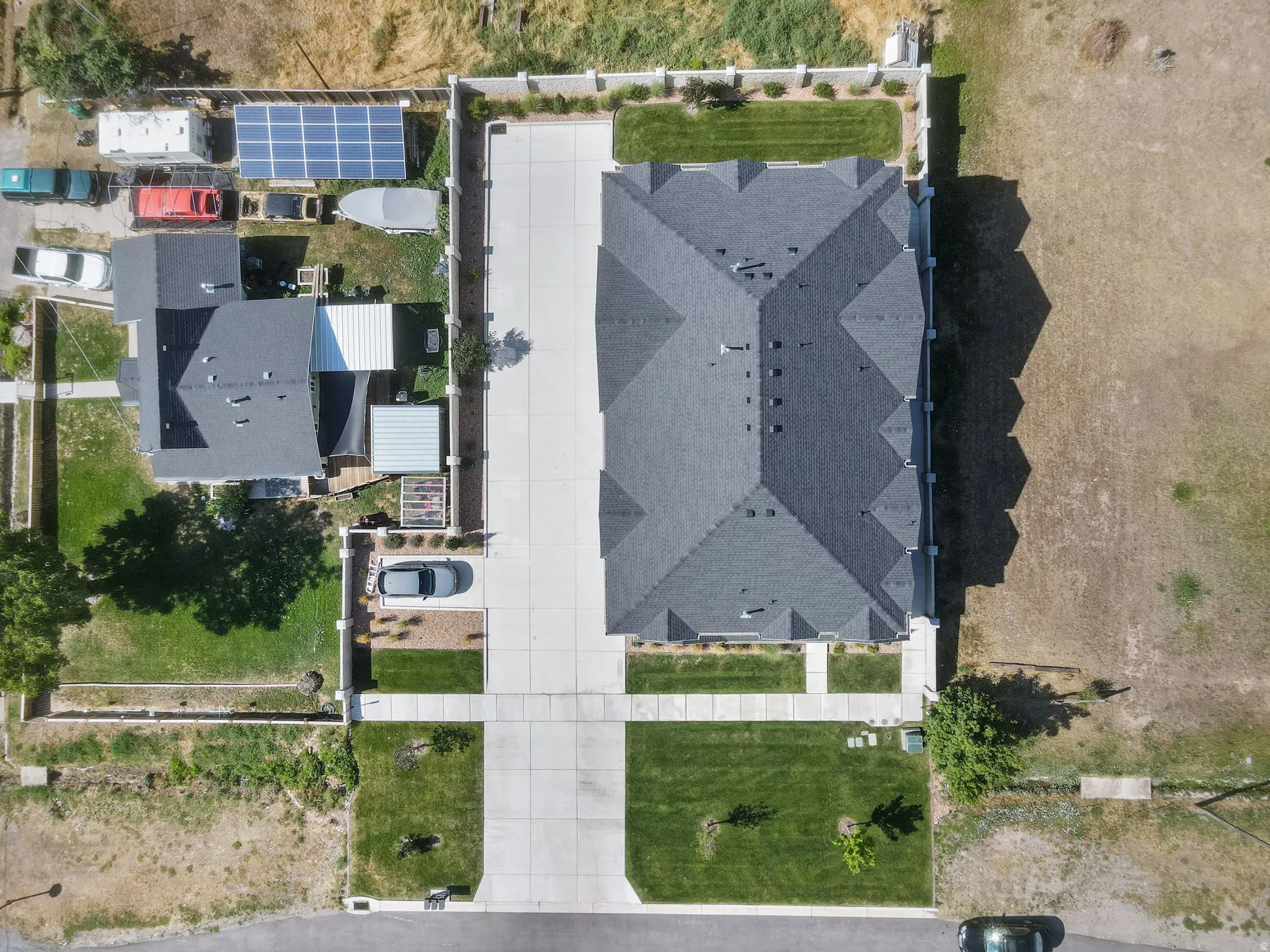 Expansive property featuring a multi-gabled roofline, a large paved driveway, and manicured lawns