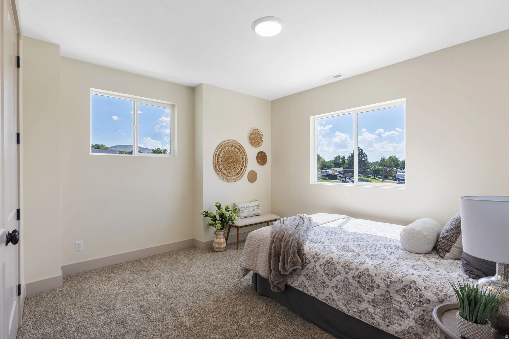 Carpeted room featuring two large windows, neutral-toned walls, and a recessed ceiling light fixture