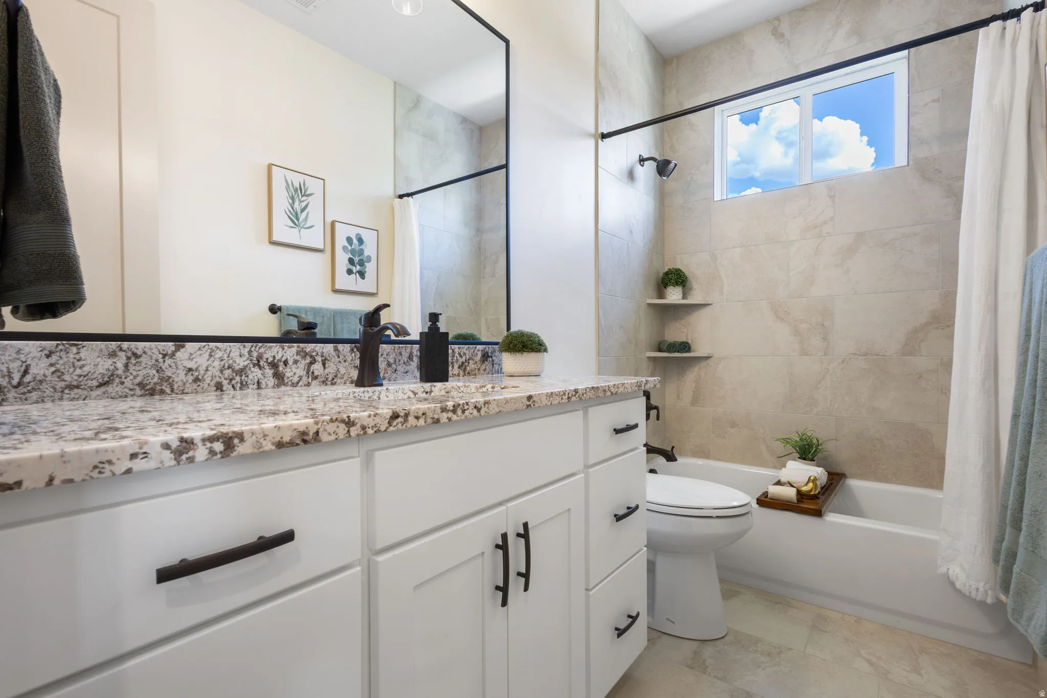 Bathroom featuring a white vanity with a granite countertop, undermount sink, and matte black hardware