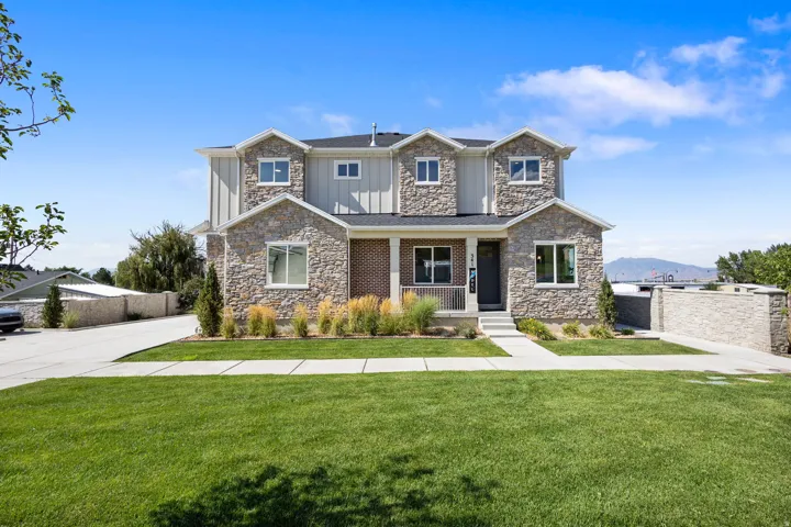 Two-story residential structure featuring a stone and siding exterior