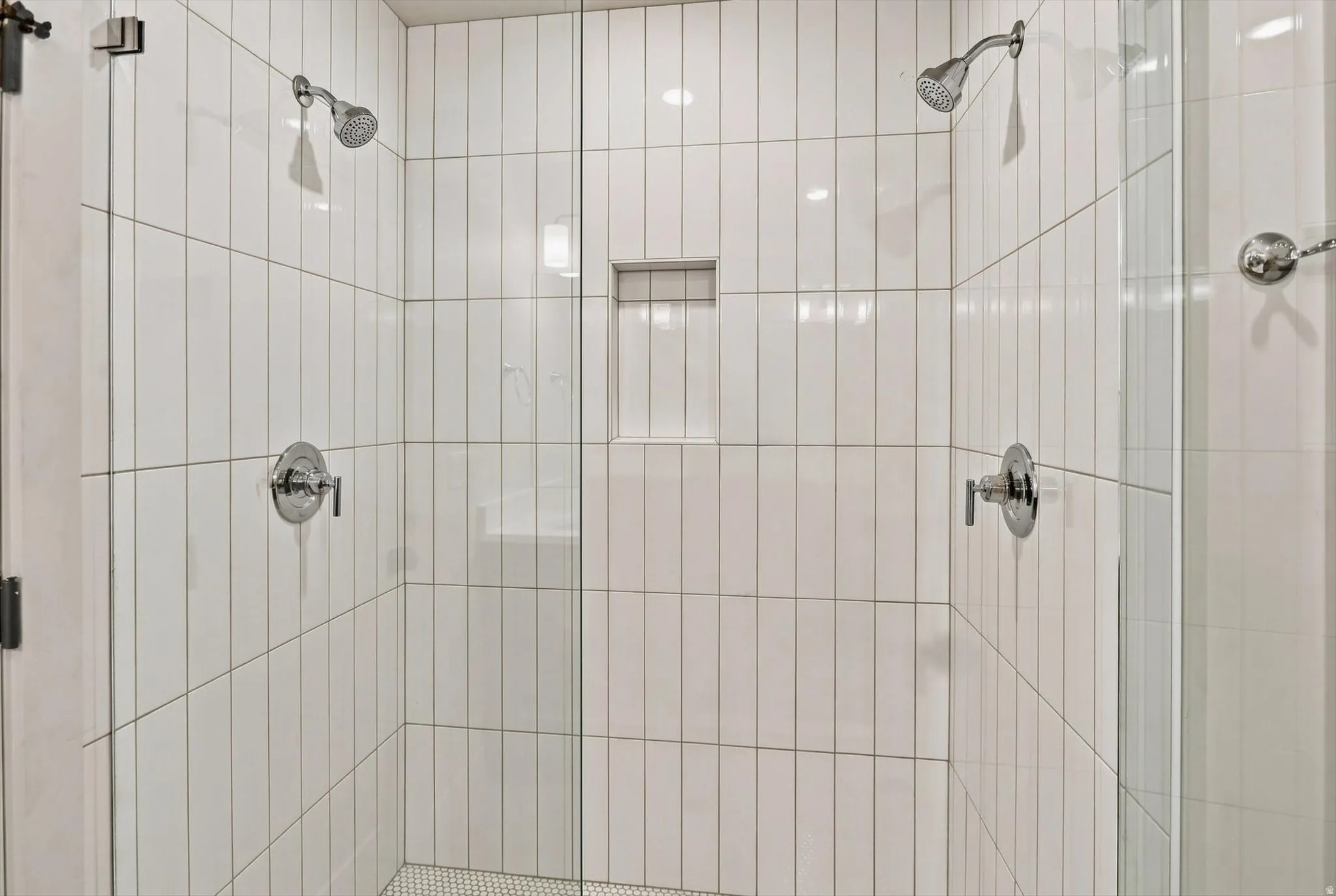 Expansive shower enclosure featuring clear glass panels and chrome fixtures