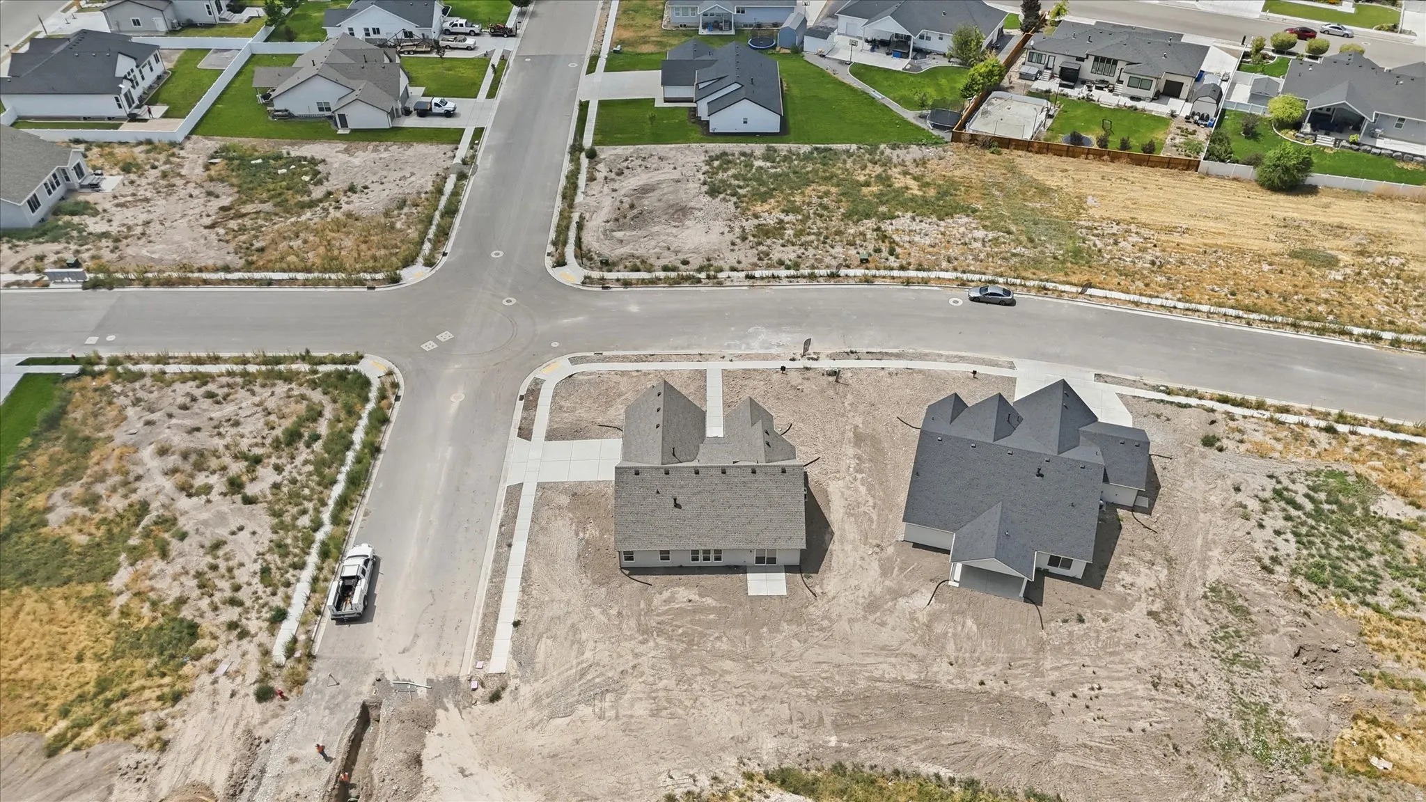 Newly constructed homes featuring multi-peak rooflines and attached garages