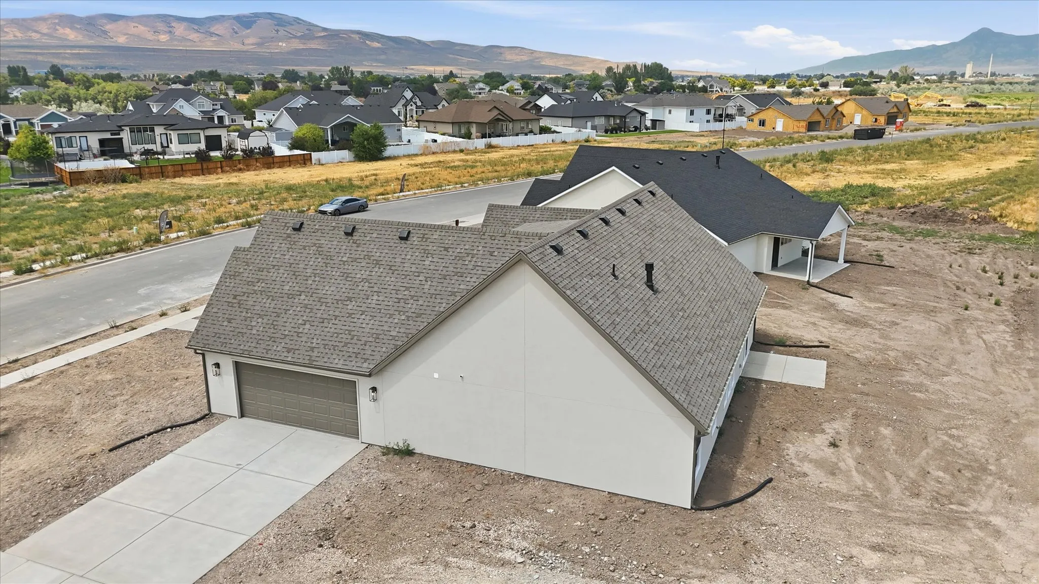 New construction residence with an attached garage, concrete driveway, and neutral exterior siding