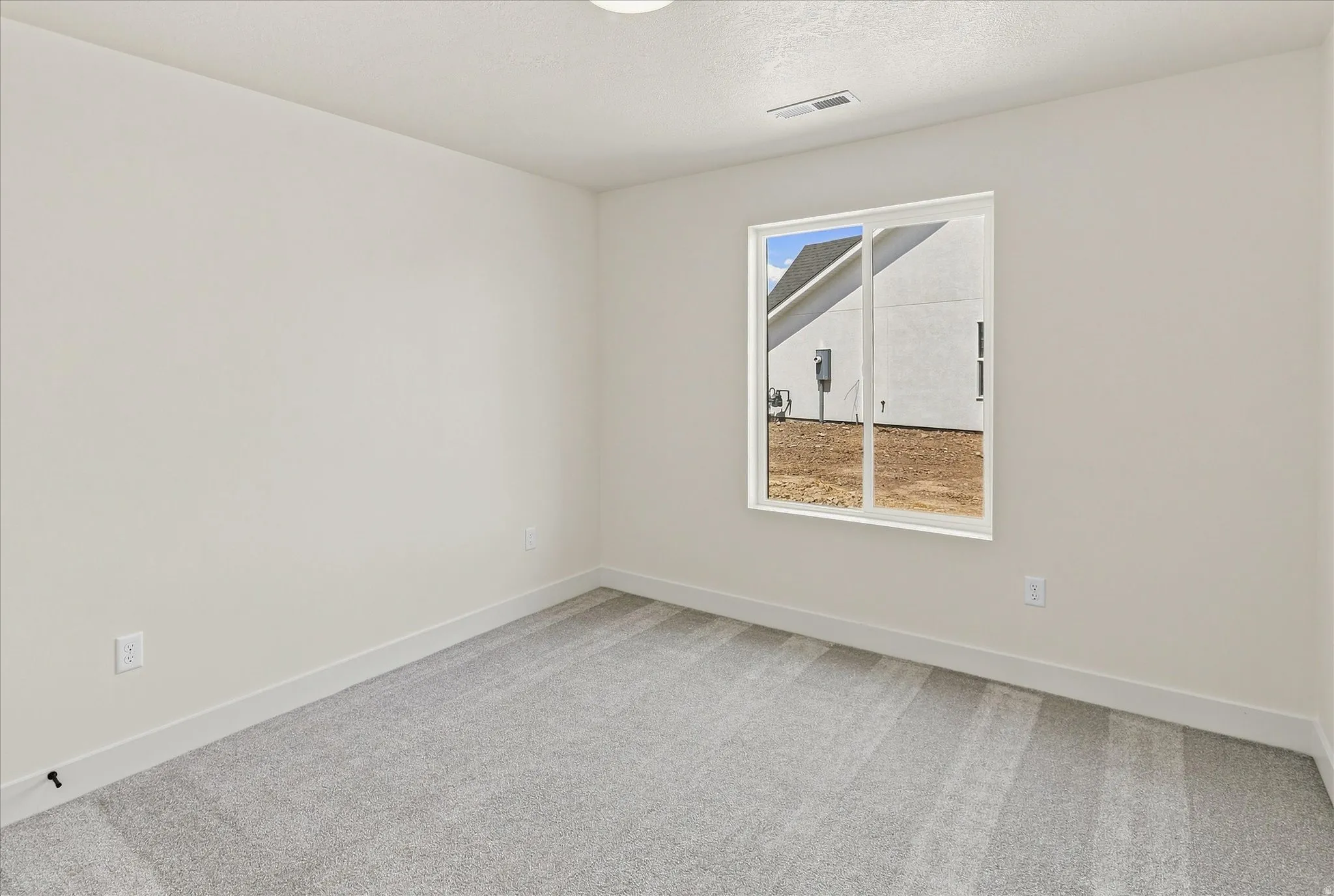 Carpeted room featuring a single window with white framing and white trim