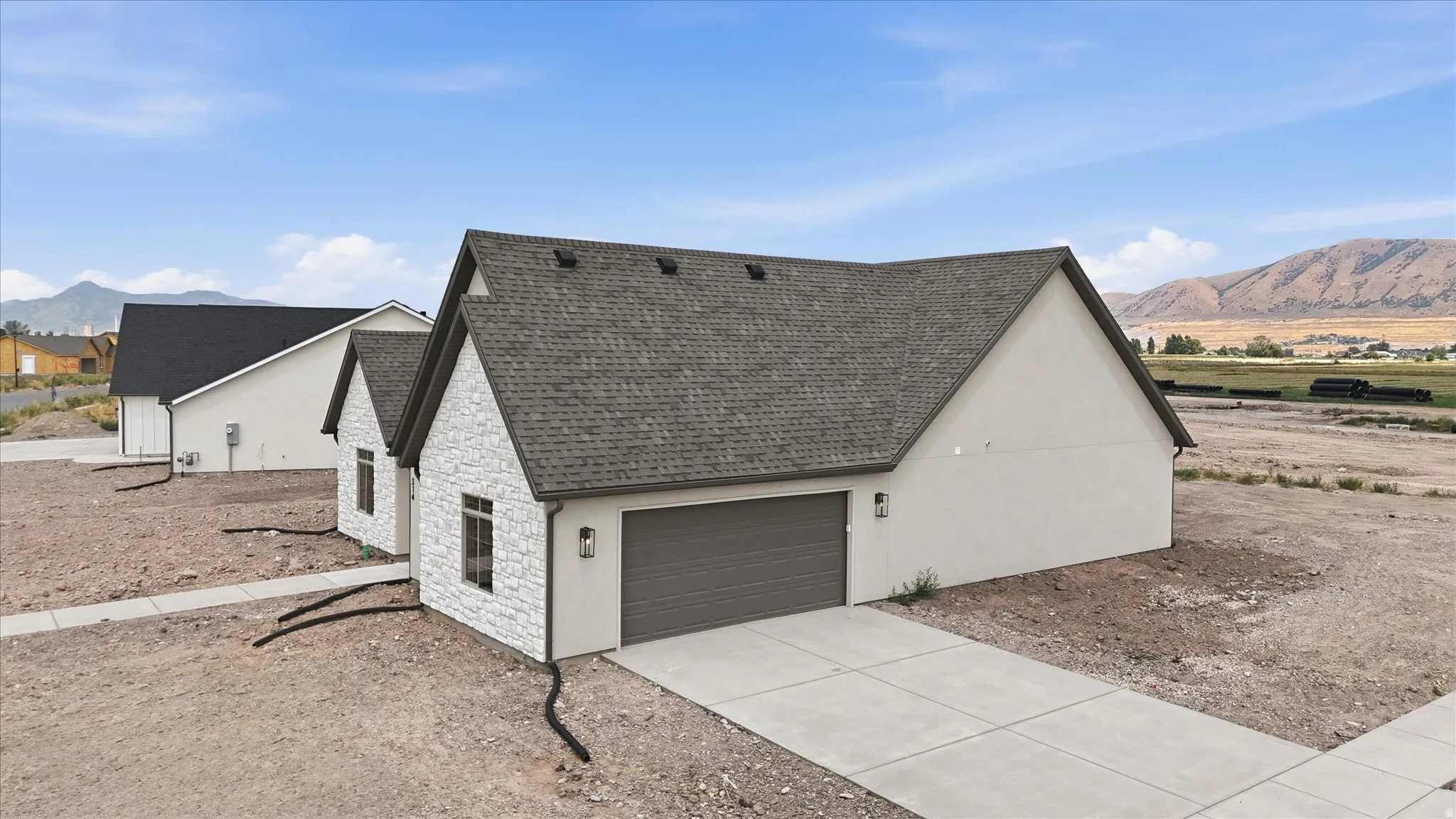 Contemporary exterior featuring white stone facade accents and neutral stucco siding