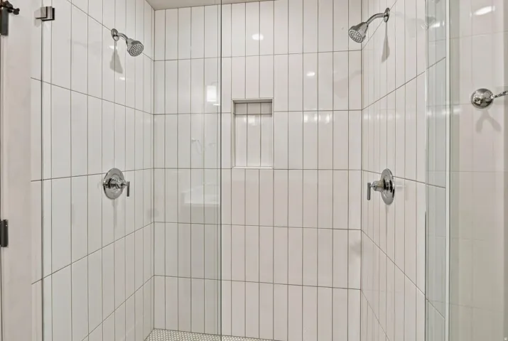 Expansive shower enclosure featuring clear glass panels and chrome fixtures