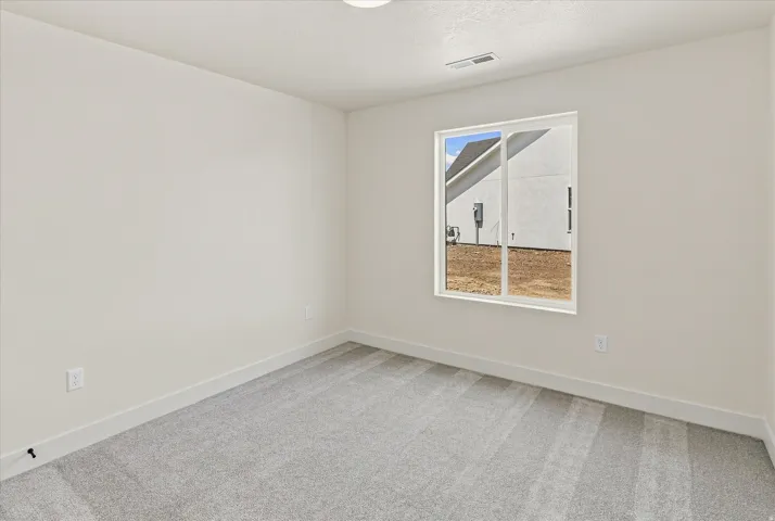 Carpeted room featuring a single window with white framing and white trim