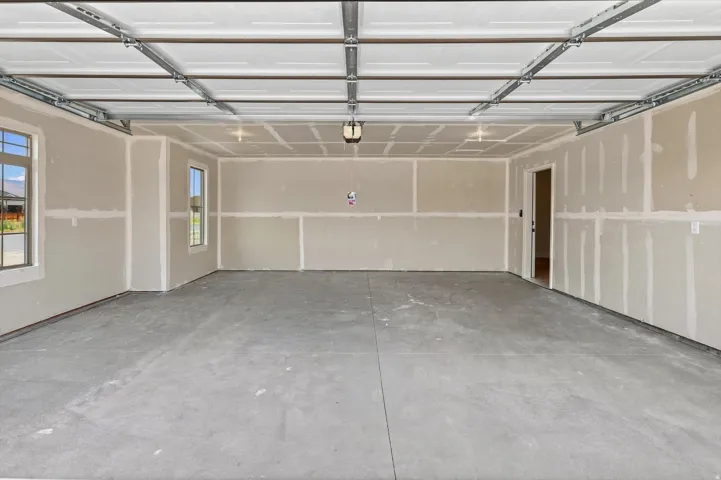 Spacious garage with a concrete floor, dual windows, and an interior access door