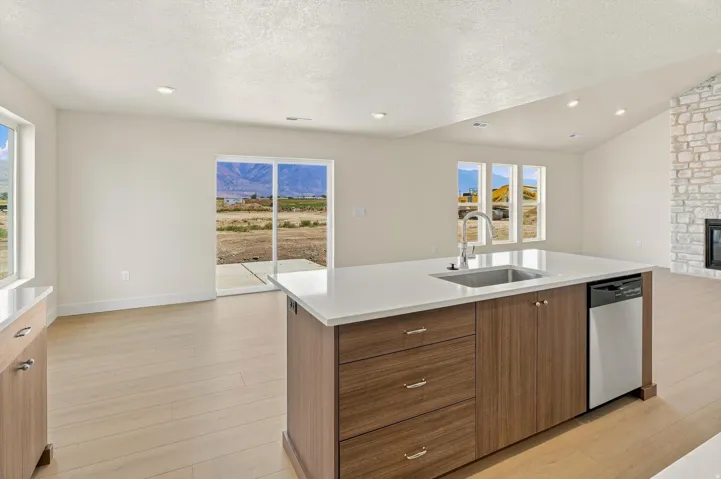 Kitchen island featuring a stainless steel sink with a high-arc faucet, integrated dishwasher, and wood-finish cabinetry