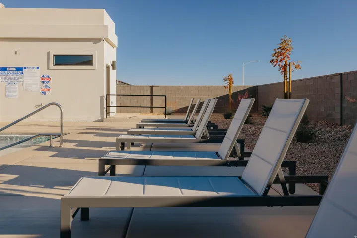Poolside area with concrete decking and modern lounge chairs