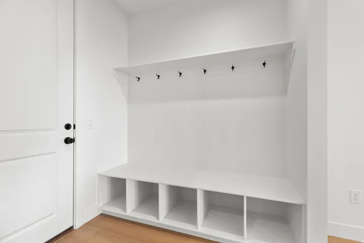 Built-in storage bench with cubbies, upper shelf, and six coat hooks