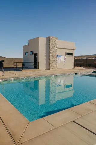 Rectangular swimming pool with light blue water and a light tan concrete deck surround