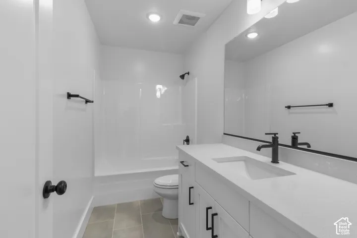 Modern bathroom vanity with a white rectangular undermount sink, light-toned countertop, and matte black fixtures