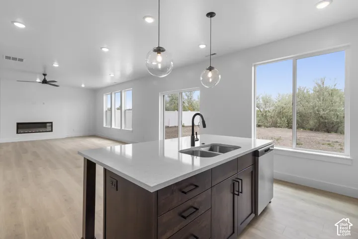Kitchen island featuring a dual-basin stainless steel sink, black gooseneck faucet, and integrated dishwasher