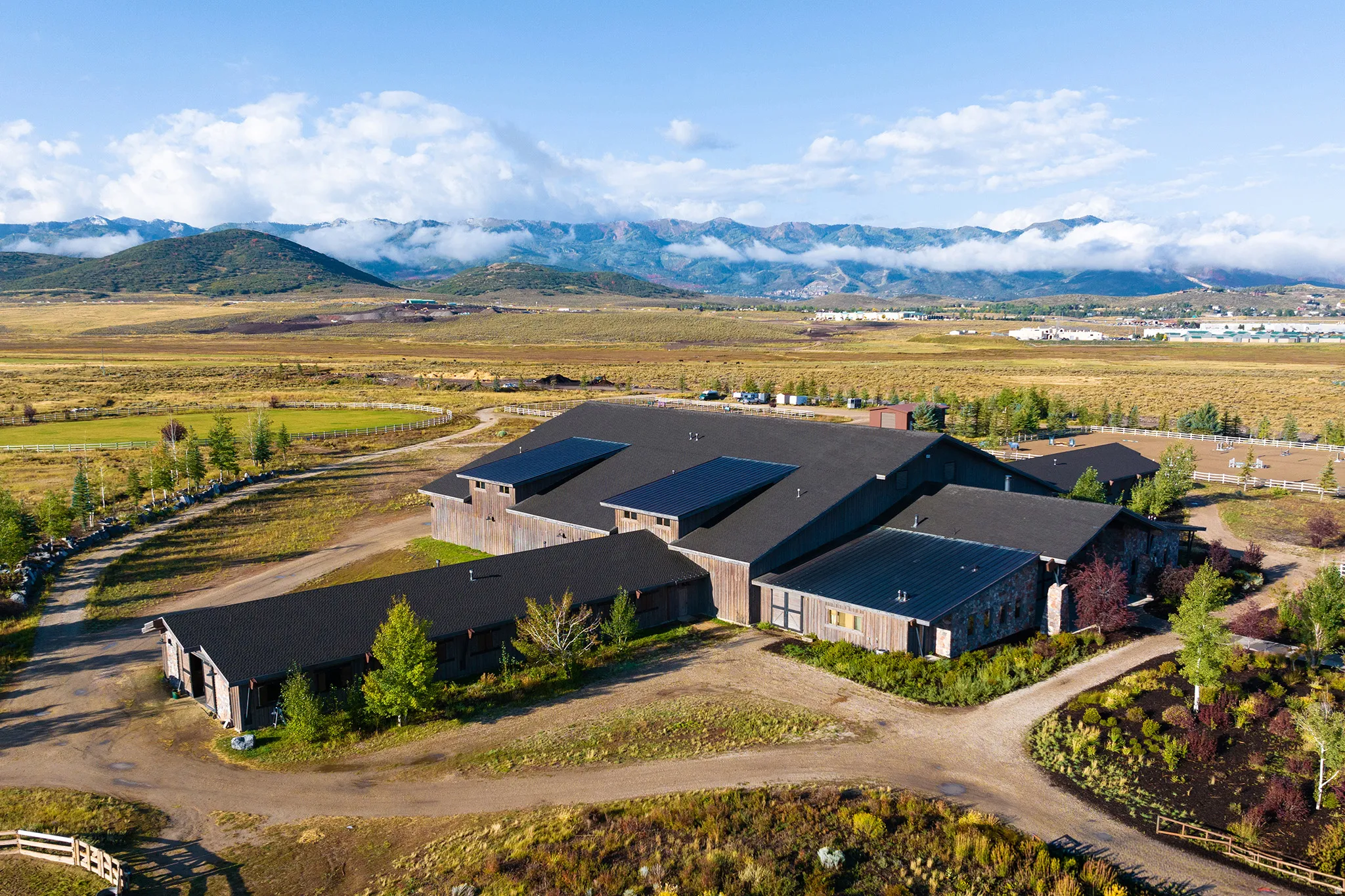 Expansive property featuring a multi-structure complex with dark roofs and wood-paneled facades