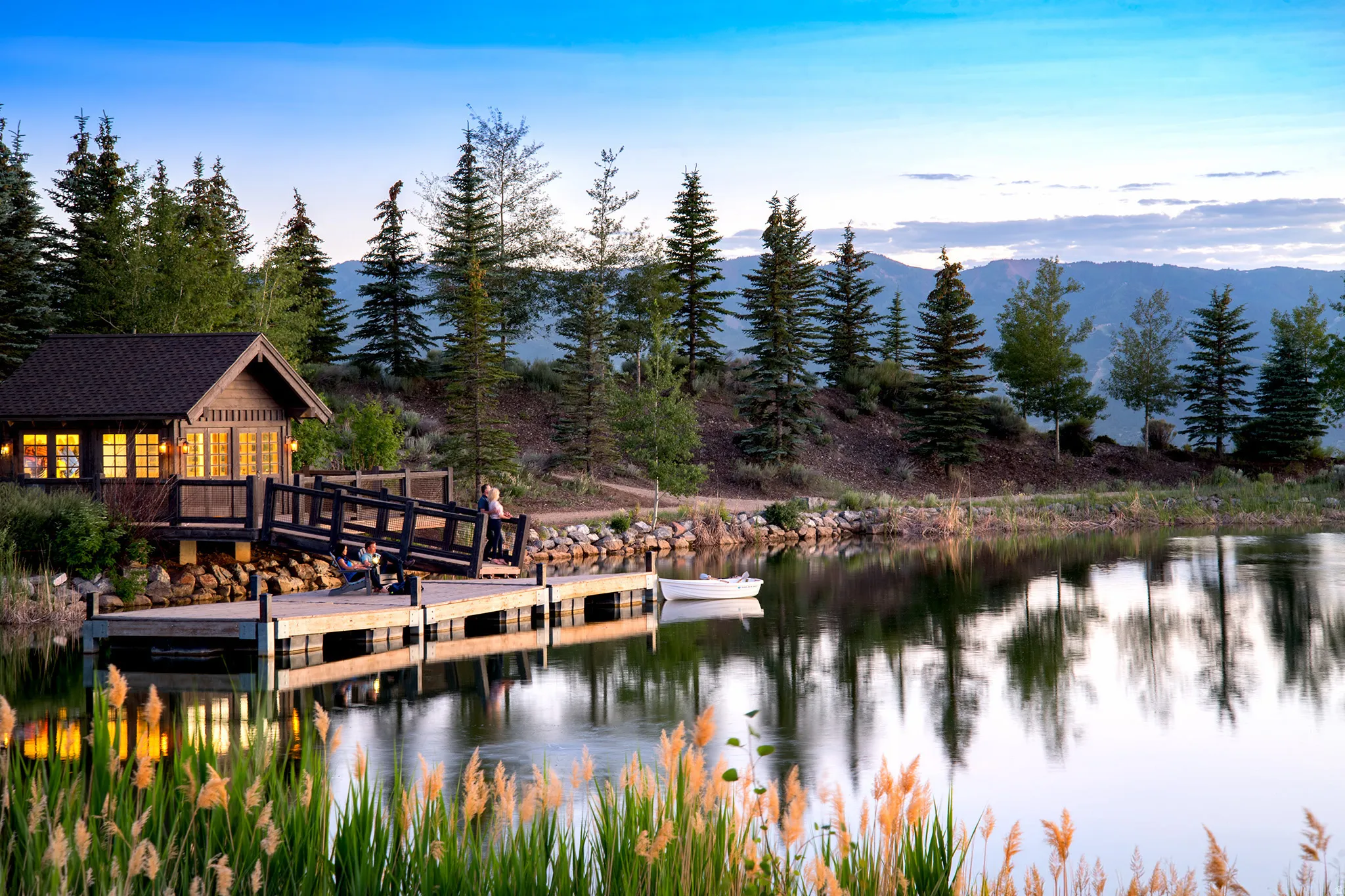 Waterside cabin featuring a dark-pitched roof, wood siding, and multiple windows