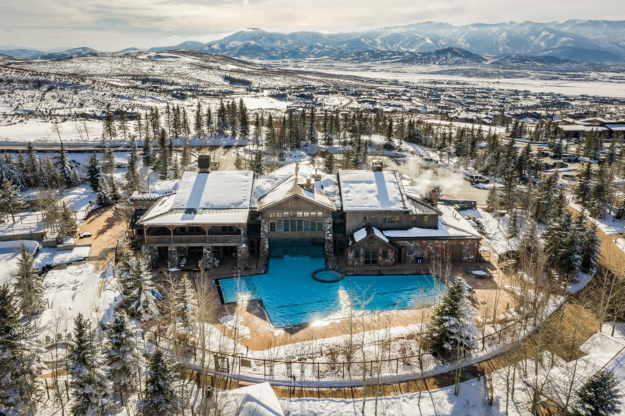 Expansive resort-style property featuring multiple buildings, a large outdoor pool, and a circular spa