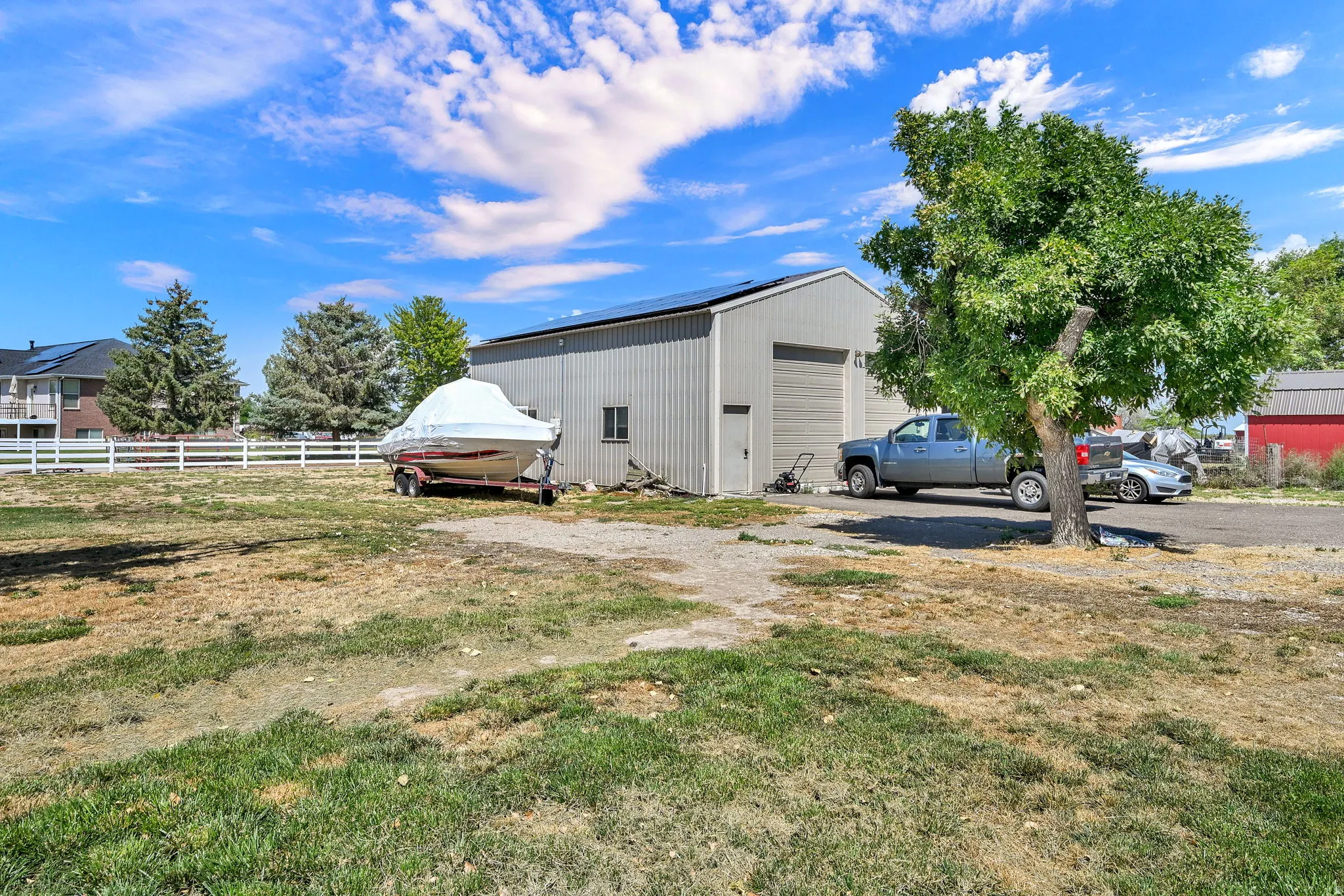 Large metal-sided auxiliary building with a roll-up garage door and an additional entry door
