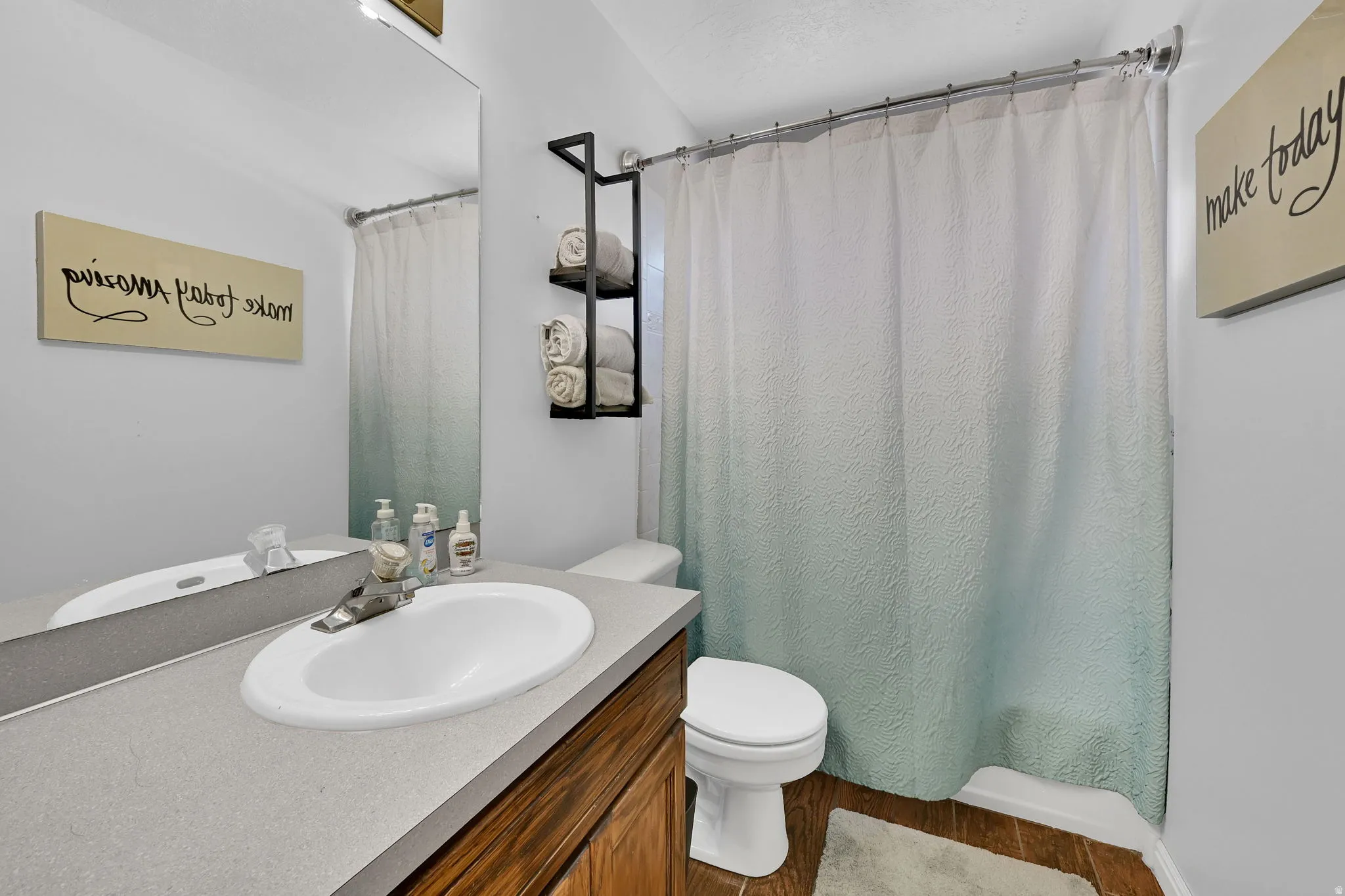 Bathroom featuring a single basin vanity with a light gray countertop and wood-finish cabinetry