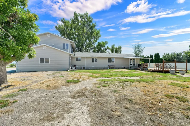Expansive backyard featuring a multi-level composite deck, covered patio, and mature trees