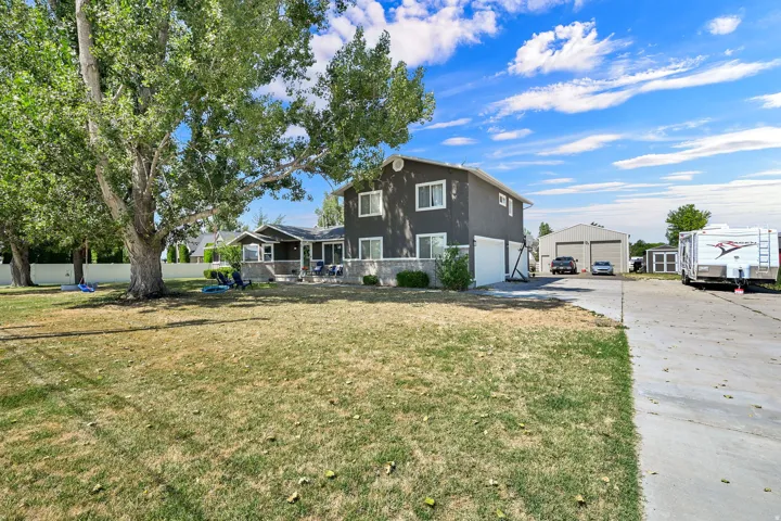 Two-story exterior with a two-car garage, multiple outbuildings, and a concrete driveway