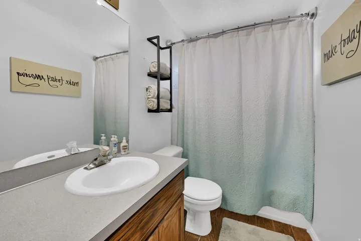 Bathroom featuring a single basin vanity with a light gray countertop and wood-finish cabinetry