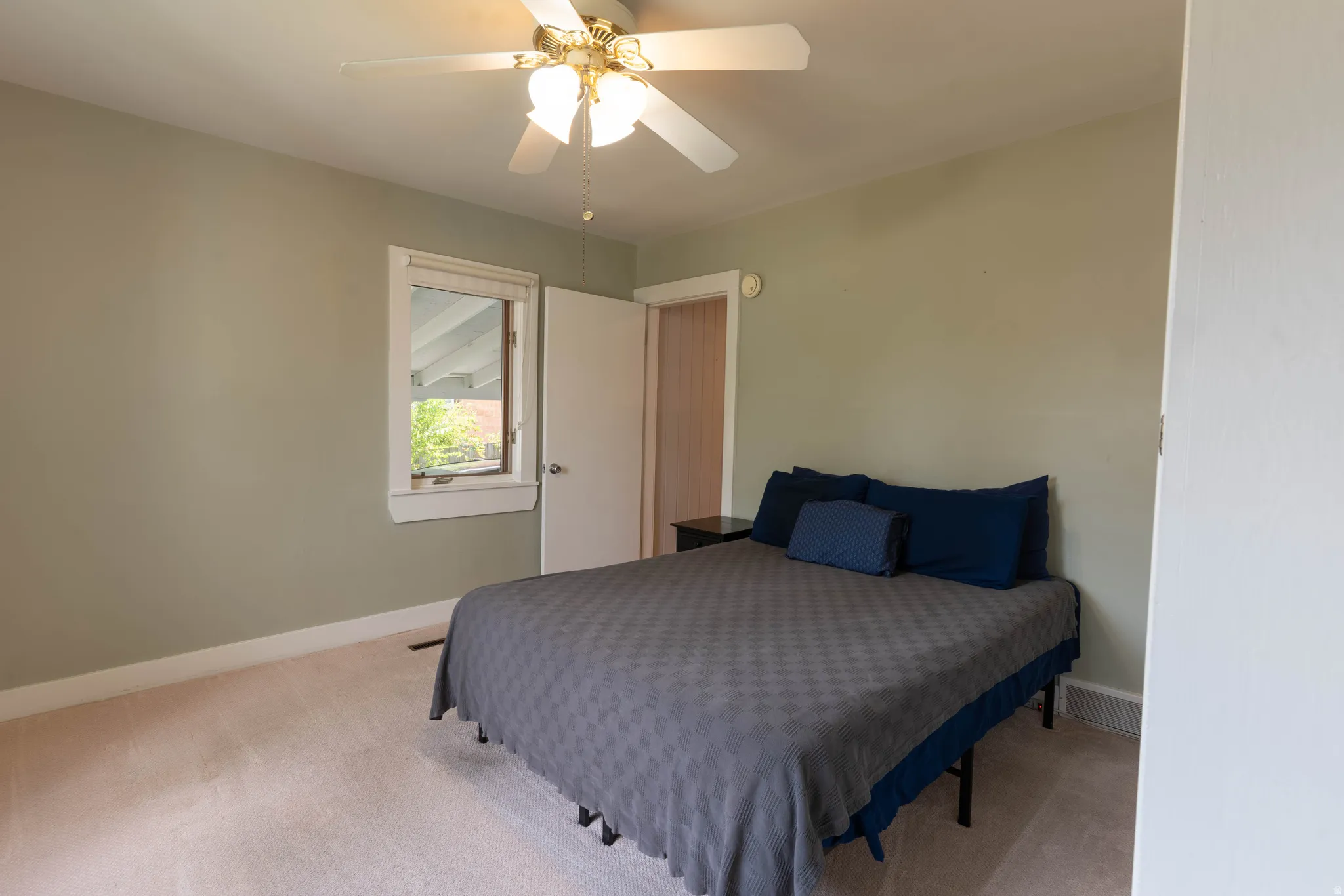 Bedroom featuring light green walls, white trim.