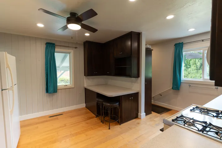 Kitchen area featuring light wood-finish flooring and big windows!  Well lite, fan and over head lights.