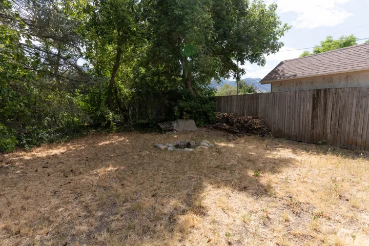 Fully fenced back yard that could keep chickens or dogs.  Fire pit