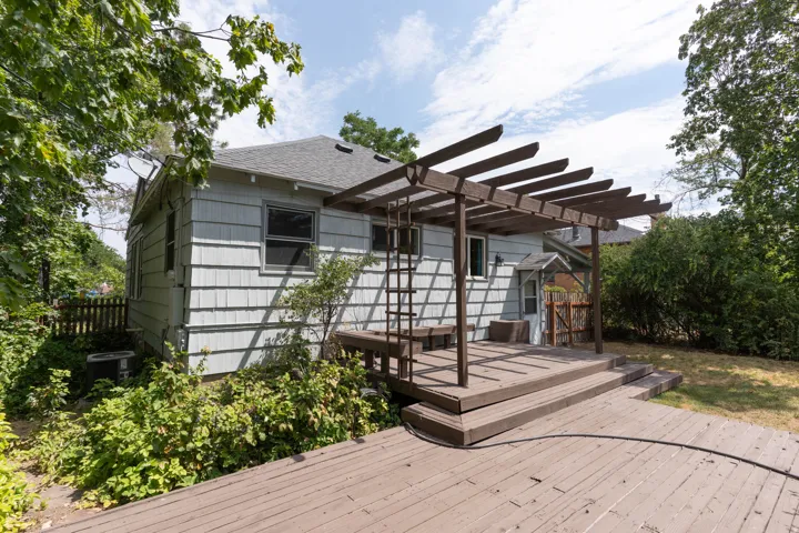 Expansive wood-finish deck featuring a pergola, integrated bench seating, and multi-level design