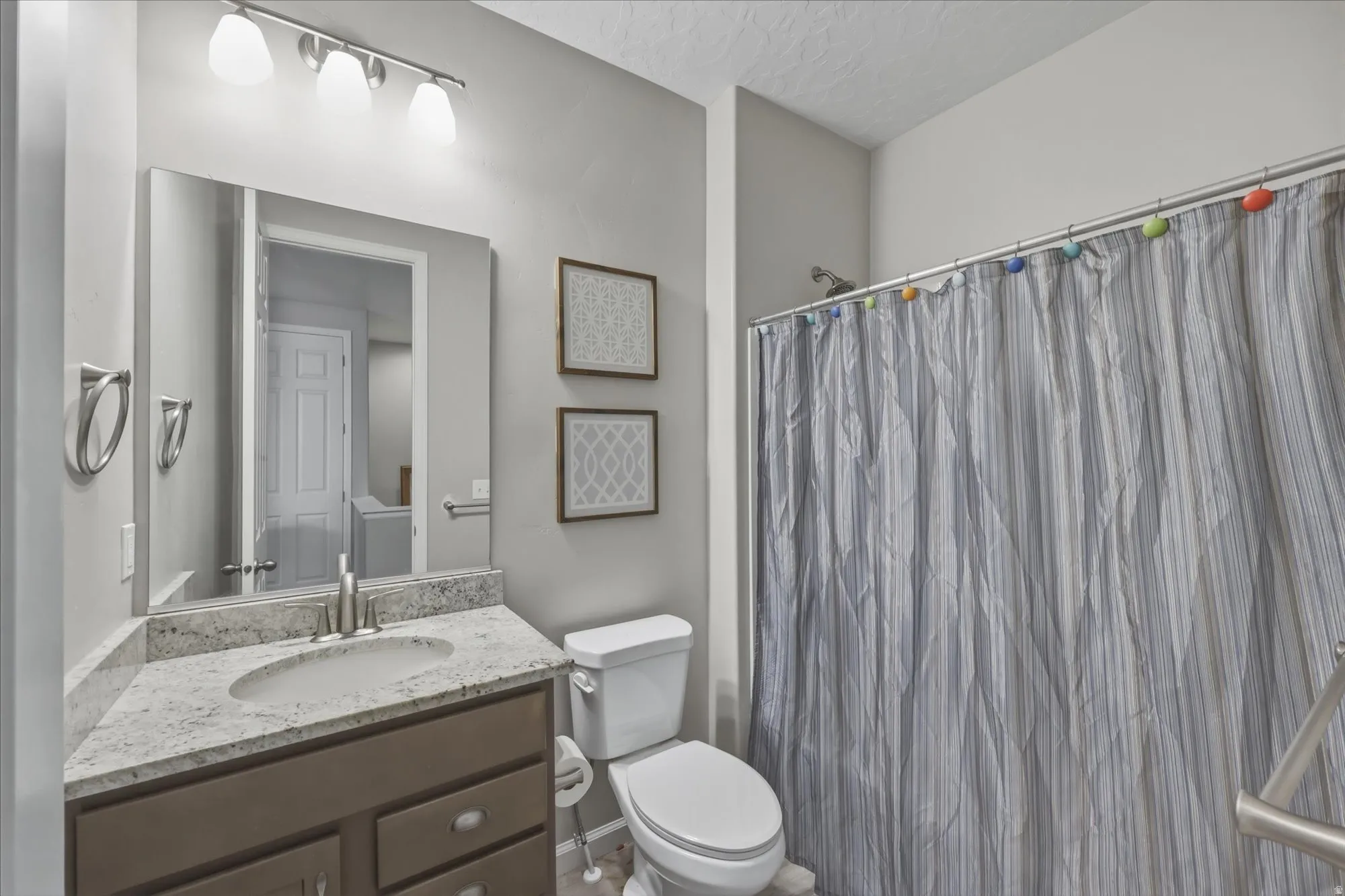 Bathroom featuring a vanity with an integrated sink, a speckled countertop, and a brushed nickel faucet