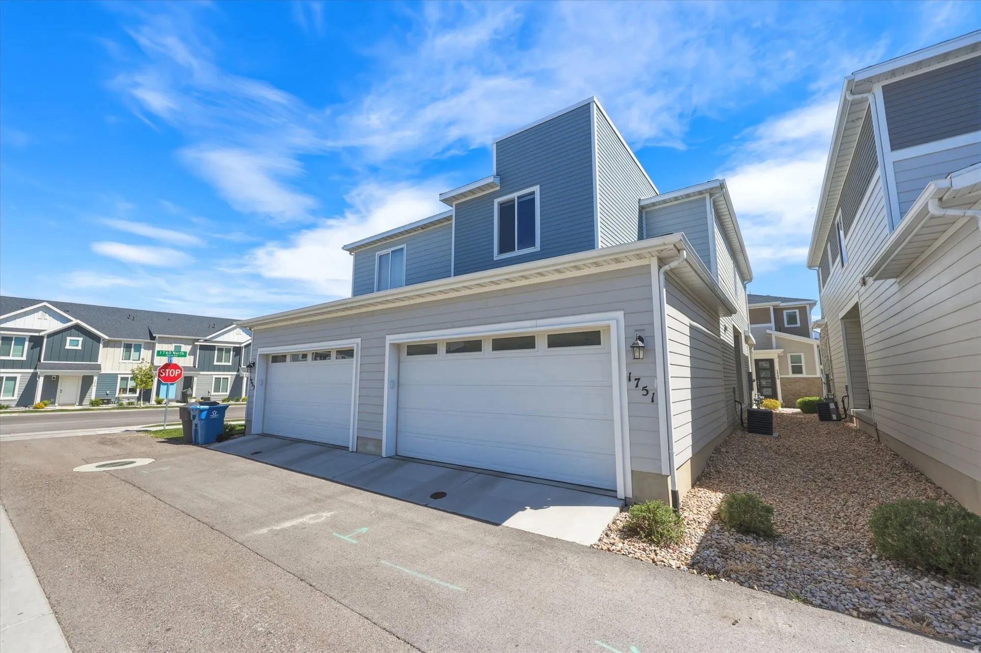 Modern multi-story property featuring light grey and blue siding