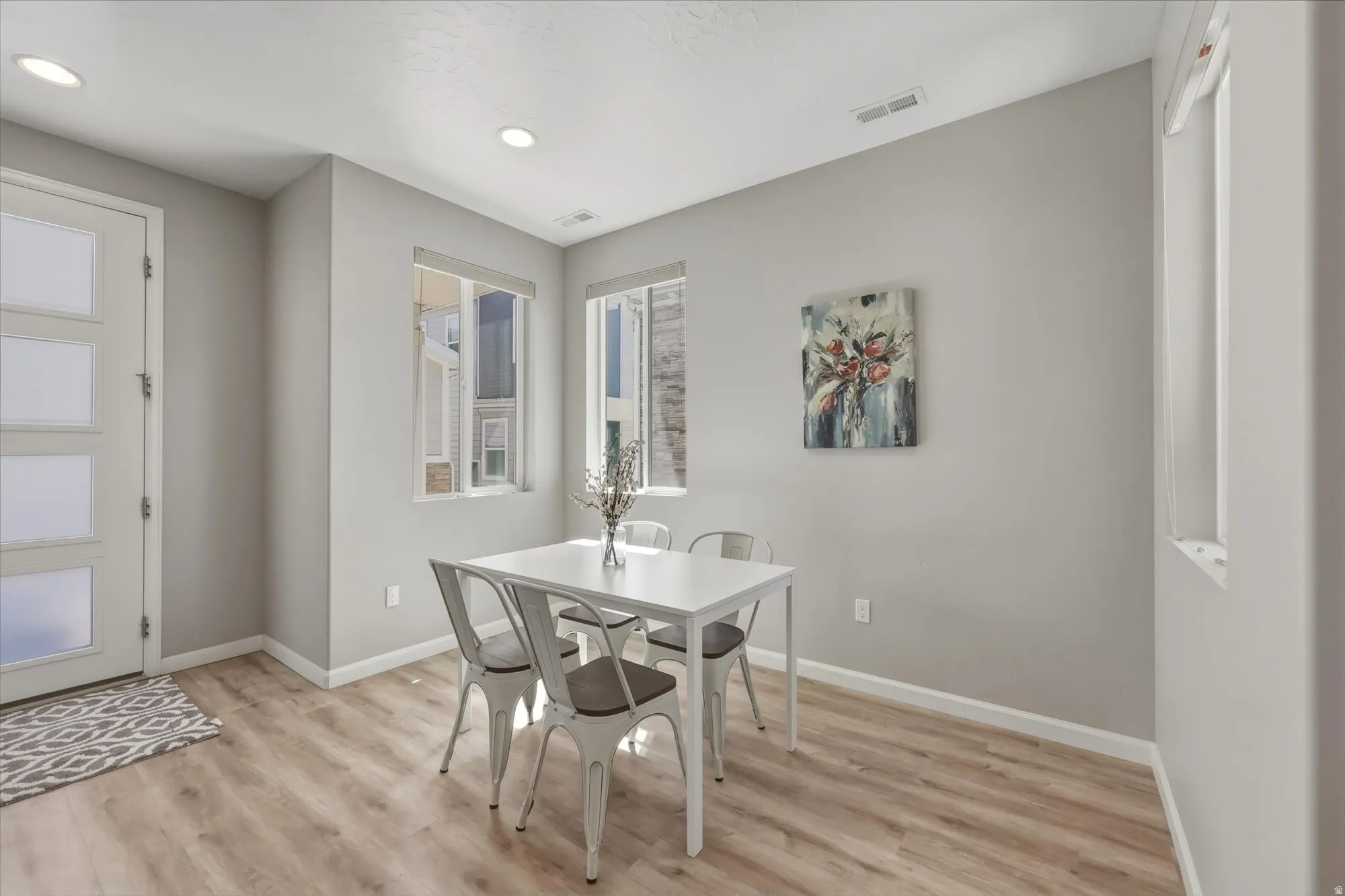 Bright interior space with wood-finish flooring, recessed lighting, and multiple windows