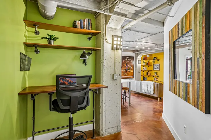 Built-in desk alcove featuring wood shelving and integrated task lighting