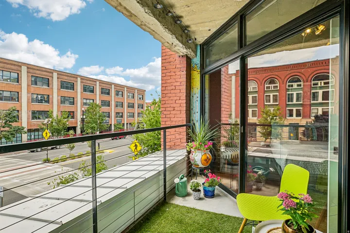 Private balcony featuring cable railings and artificial turf flooring
