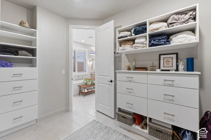 Custom closet system featuring built-in shelving, drawers with brushed nickel hardware, and integrated storage cubbies