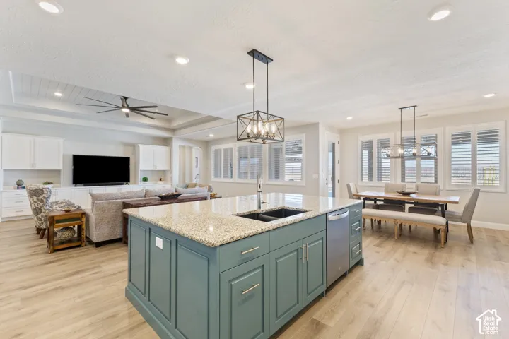 Open-concept living space featuring a central kitchen island with a stone-finish countertop and integrated sink