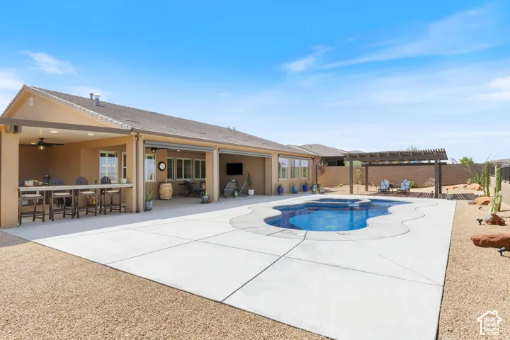 Custom-shaped swimming pool with integrated spa and surrounding concrete decking