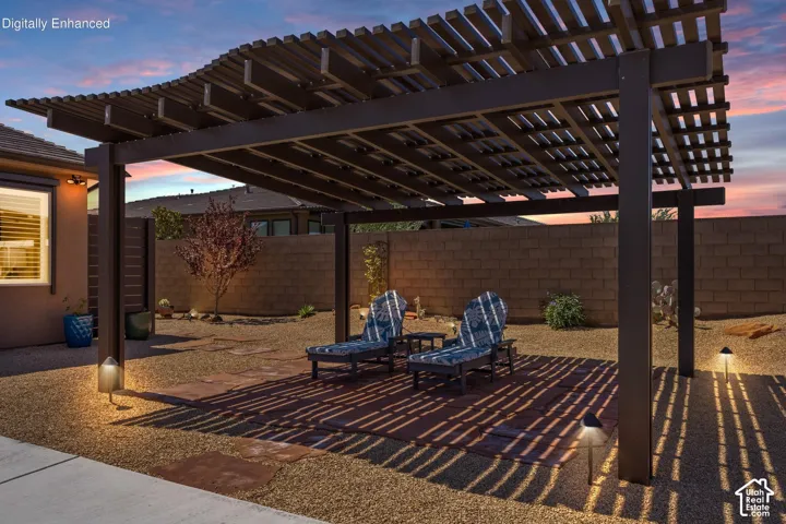 Expansive backyard featuring a dark wood pergola with a curved slatted roof, gravel ground cover, and integrated landscape lighting